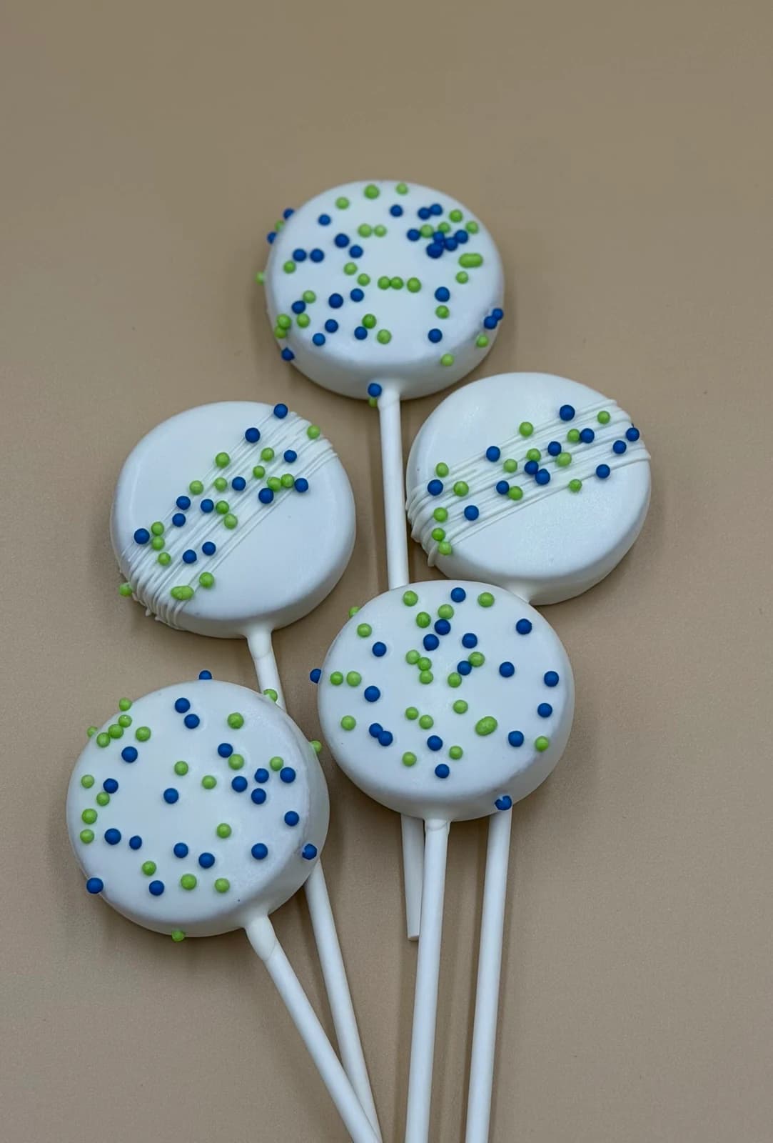 Classic white chocolate cake pops covered in blue and green sprinkles