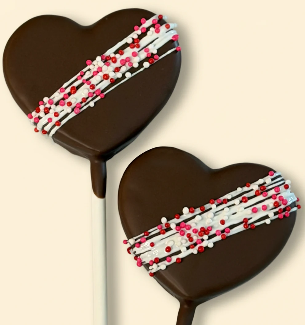 Heart-shaped chocolate cake pops with red, white, and pink Valentine's sprinkles.