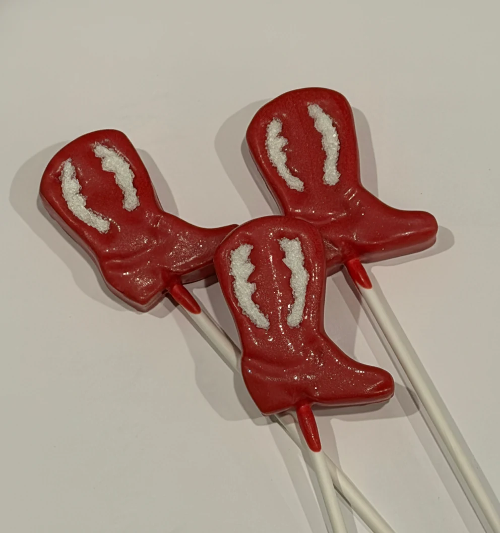 Red cowboy boot shaped cake pops with white sugar detail.